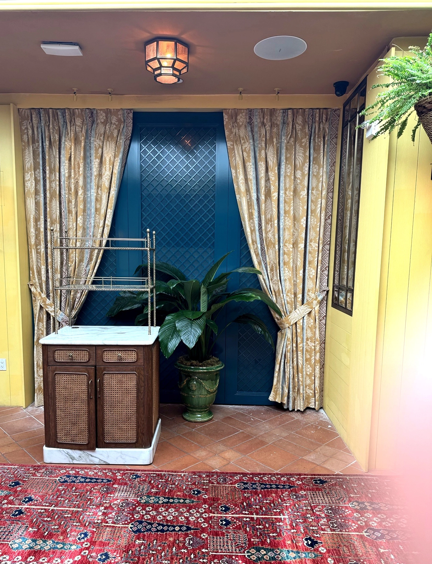 Custom pinch pleat drapery panel with fabric tie back and cane credenza, The Conservatory at The Fifth Avenue Hotel